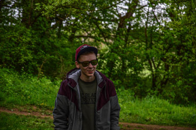 Portrait of young man standing in forest