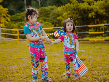 Full length of smiling girl standing outdoors