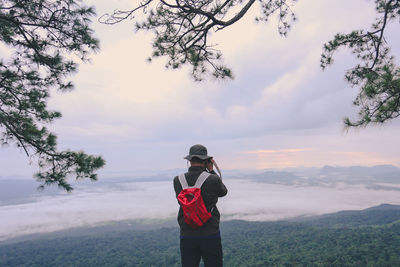 Full length of man standing on mobile phone against sky