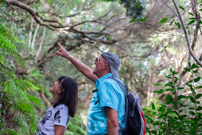 Side view of woman standing against trees