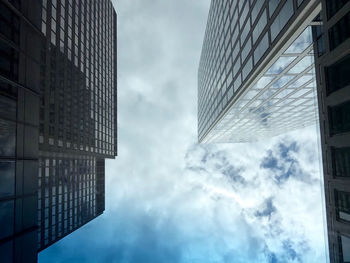 Low angle view of modern building against cloudy sky