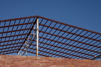 Low angle view of metallic roof frame against clear sky