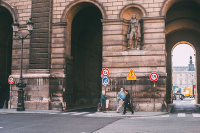 People on street against buildings in city