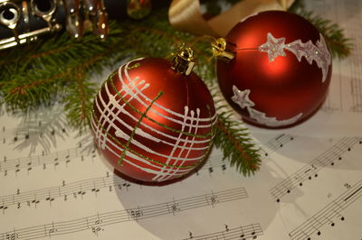 Close-up of christmas ornaments on musical notes