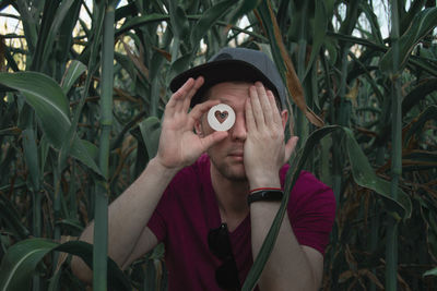 Portrait of young man holding plant