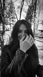 Portrait of young woman smoking in park