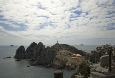 Rock formations by sea against sky