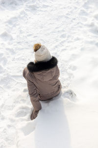 Rear view of man walking on snow