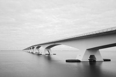 Low angle view of bridge over river against sky