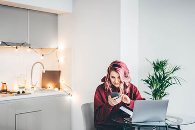 Young woman using laptop while sitting at home