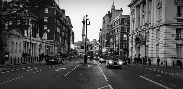 Cars on city street amidst buildings