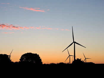 Silhouette of wind turbines at sunset