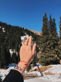 Midsection of person on snow against clear sky