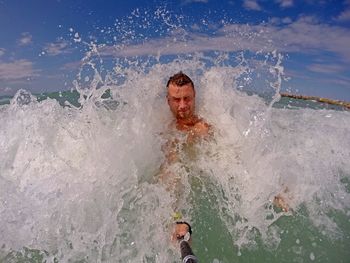 Wave splashing on man in sea