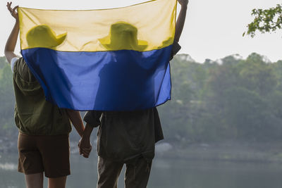 Two women stand hand in hand waving the ukrainian flag. campaign to stop the war