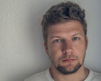 Close-up portrait of man against wall