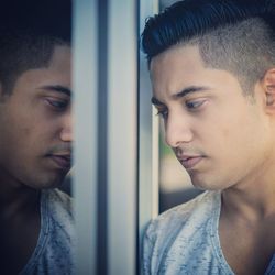 Close-up of man looking through window