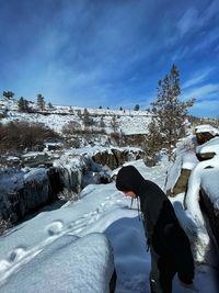 Man skiing on snowcapped mountain against sky