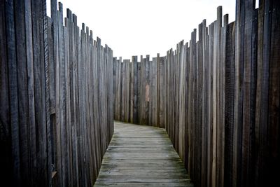 Boardwalk amidst wooden fence