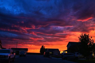 Vehicles on road against orange sky