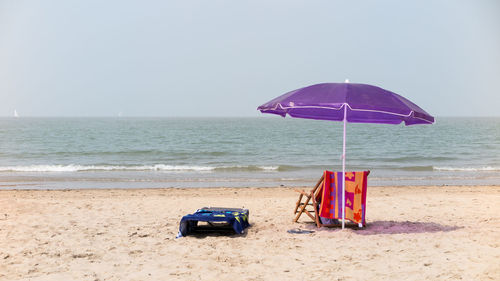 Deck chairs on beach against clear sky