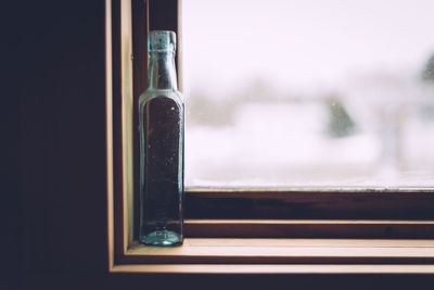 Close-up of glass bottle on window sill