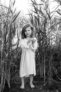 Portrait of smiling girl standing amidst plants