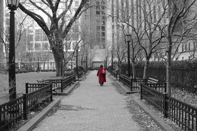 Rear view of woman walking on footpath