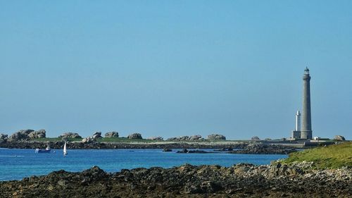 Scenic view of shore and sea against clear sky