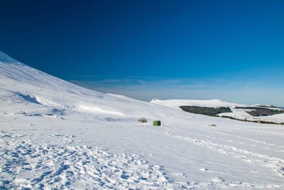 Scenic view of snowcapped mountains against blue sky