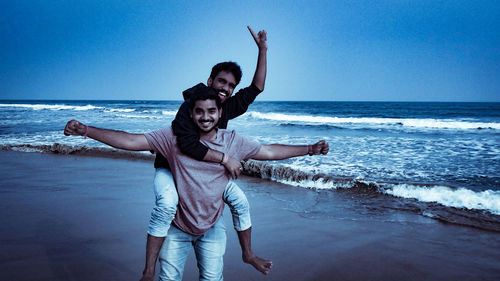 Portrait of cheerful friends enjoying on beach