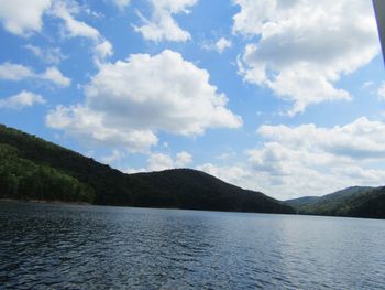 Scenic view of lake by mountains against sky