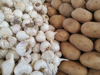 Close-up of potatoes and garlics for sale at market