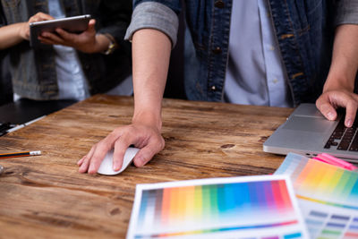 Midsection of man using mobile phone on table