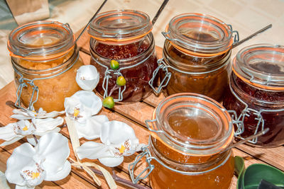 High angle view of preserves and flowers on table