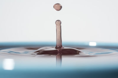 Close-up of water drops on table against white background
