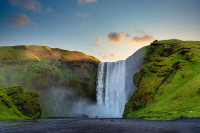 Scenic view of waterfall against sky