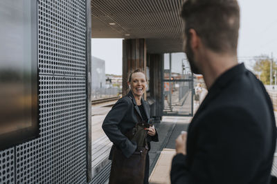 Businesswoman laughing while looking at businessman