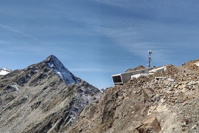 Low angle view of buildings on mountain against sky