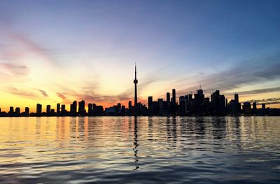 Silhouette of buildings in city during sunset
