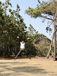 Man playing with umbrella against trees