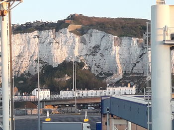Panoramic shot of buildings and mountains seen through glass window