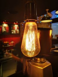 Close-up of illuminated light bulb on table