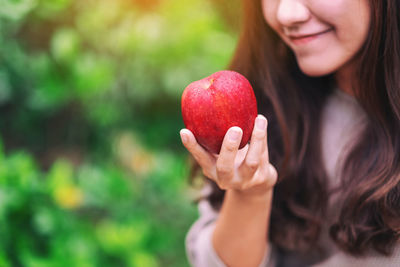 Midsection of woman holding apple