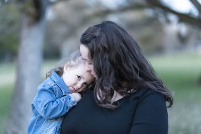 Side view of mother and daughter outdoors