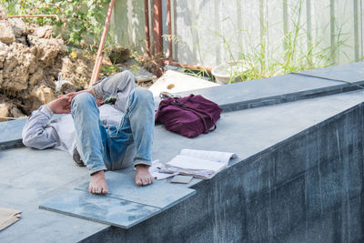 Man sleeping on floor against wall