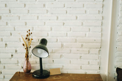 Close-up of vase on table against wall