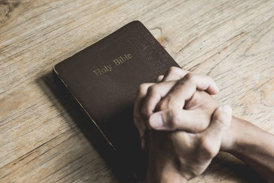 Close-up of hand holding book on table