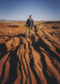 A man with a dog is standing near horseshoe bend, arizona