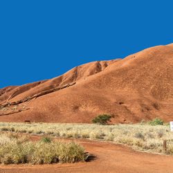 Scenic view of arid landscape against clear blue sky